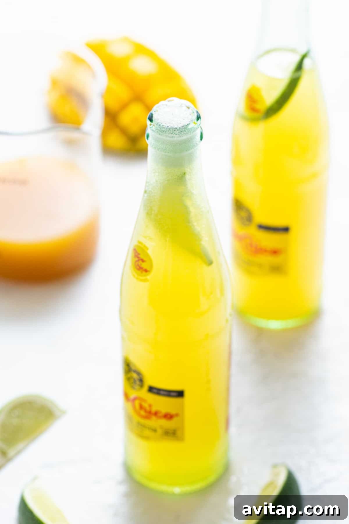 Homemade Ranch Water: Topo Chico, Tequila, and Fruit Juice Cocktail A refreshing bottle of homemade Ranch Water with lime, sitting on a sunlit surface.