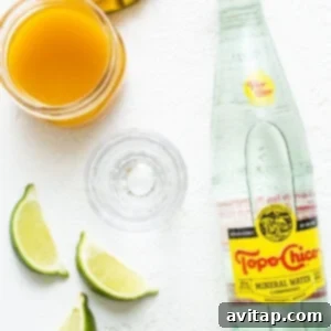 A bottle of water with limes and a slice of lime.