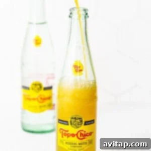 A bottle of orange juice being poured into a glass.