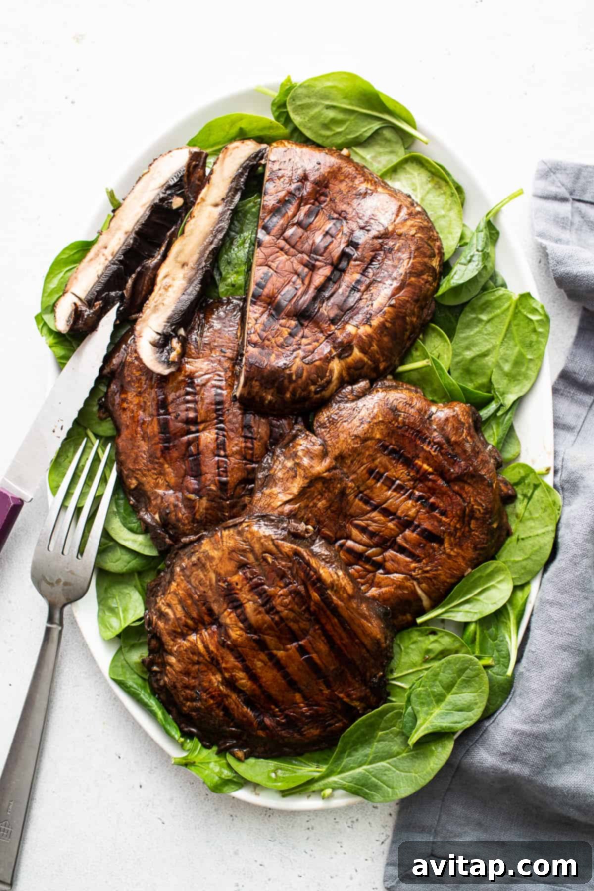 Perfectly grilled portobello mushrooms, richly colored and served on a plate, ready to be enjoyed.