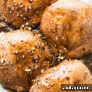 Chicken breasts in a baking dish with sauce and sesame seeds.