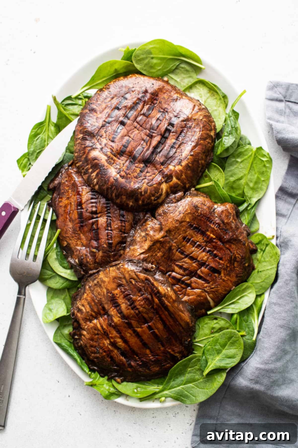 A vibrant plate featuring perfectly grilled portobello mushrooms, showcasing their rich color and succulent texture, garnished for serving.