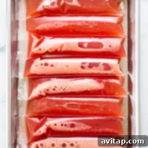 Watermelon wine freeze pops laid out flat on a baking sheet, ready for the freezer.