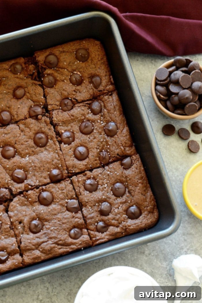Perfectly baked Flourless Cashew Butter Brownies cooling in the pan, highlighting their rich chocolate color and fudgy texture.
