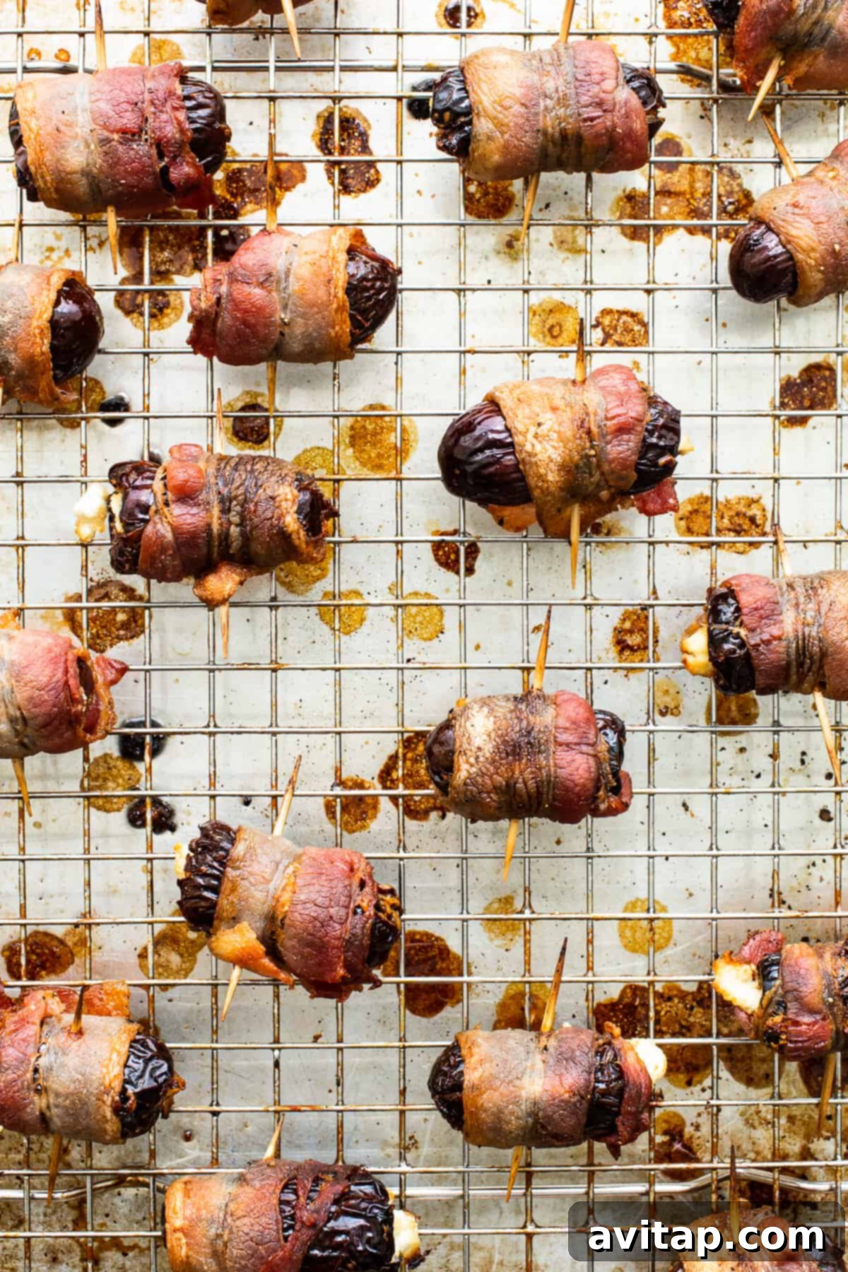 Bacon wrapped dates with goat cheese on a baking sheet, ready for the oven.