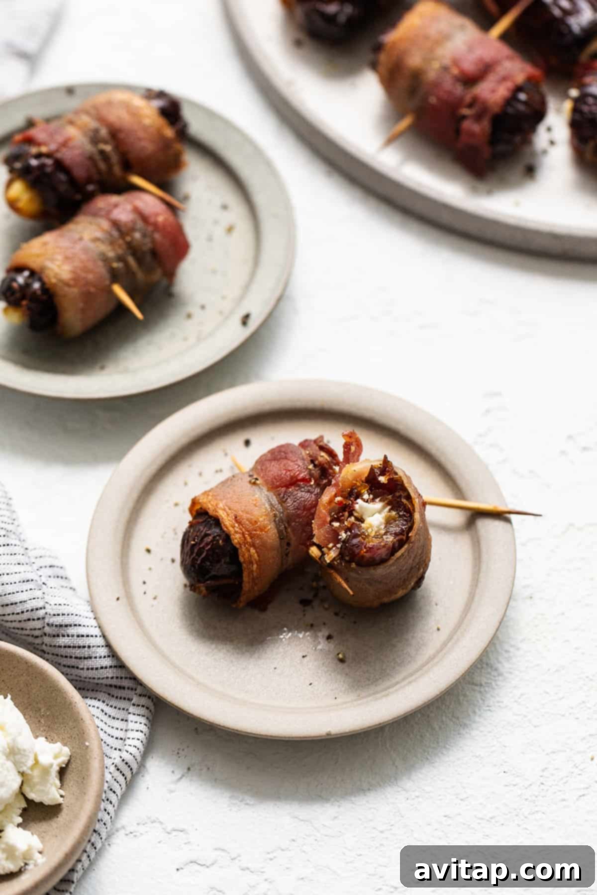 Bacon wrapped dates with goat cheese in a serving bowl.