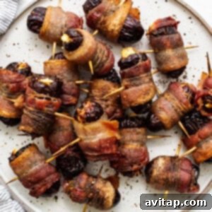 Bacon wrapped dates on a plate, garnished.