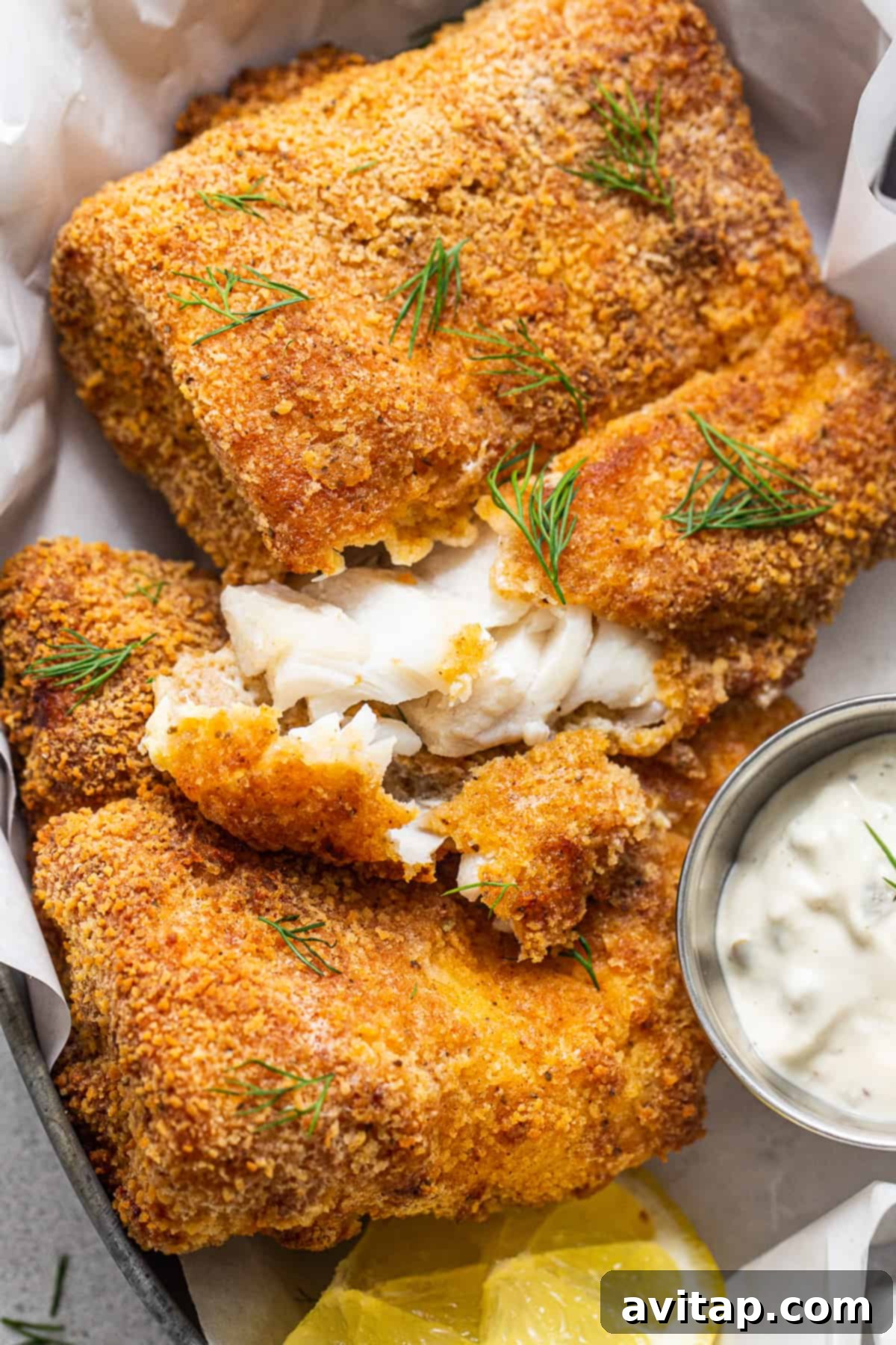 Flaky air fryer fish with tartar sauce.