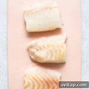 Raw cod on a cutting board.