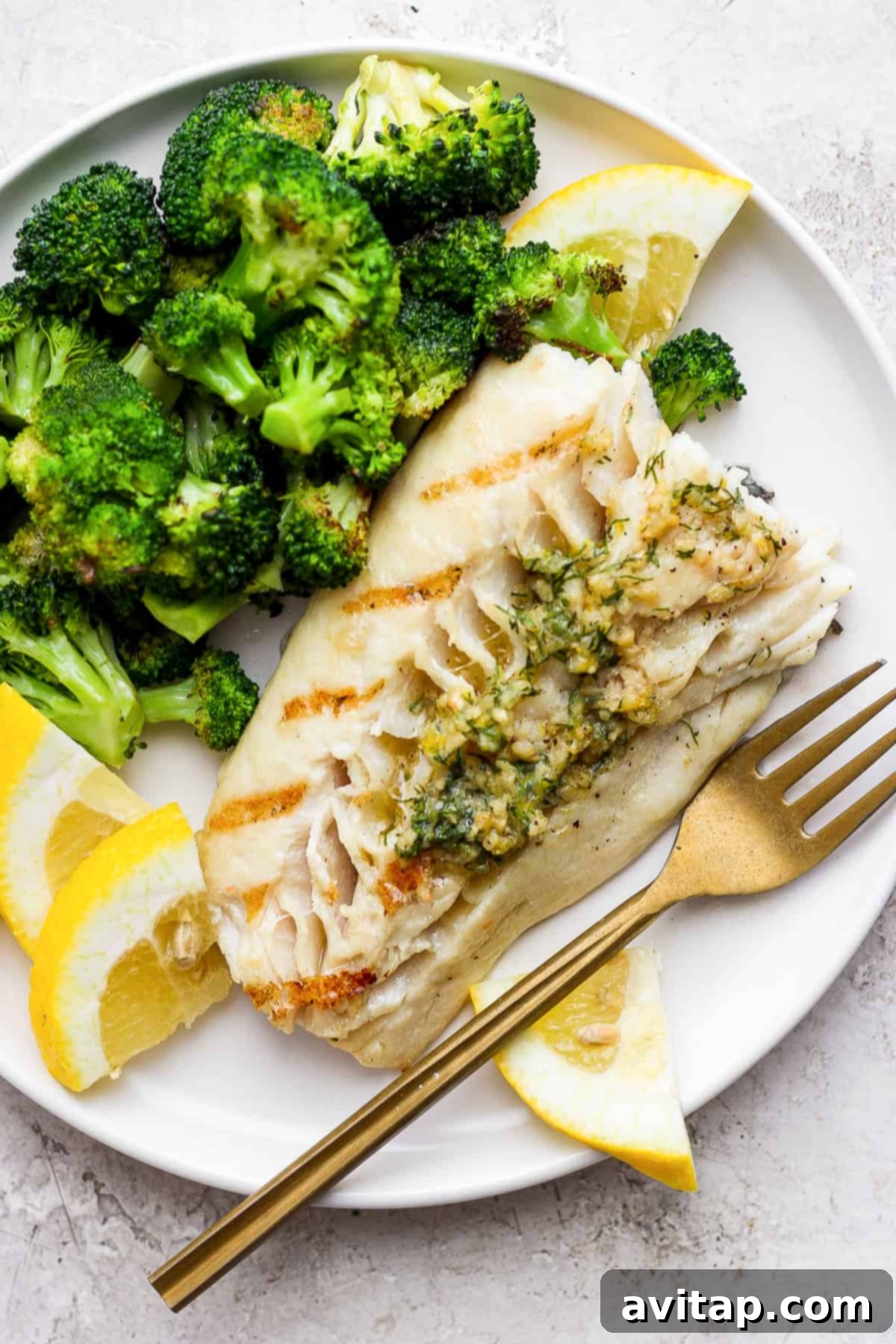Grilled fish on a plate with broccoli, perfectly cooked and ready to serve.