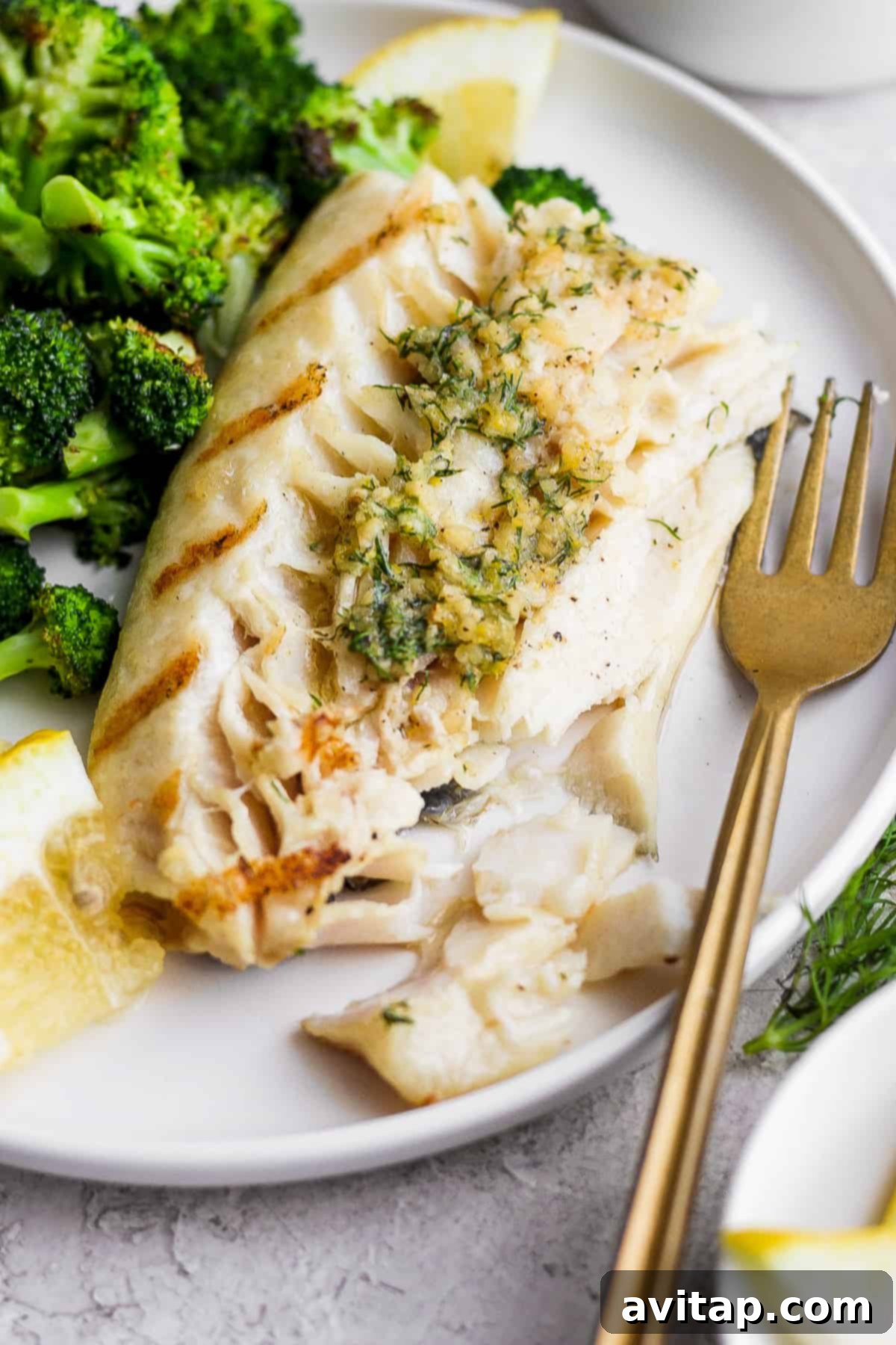 Grilled fish on a plate with broccoli, a close-up shot of the finished dish.