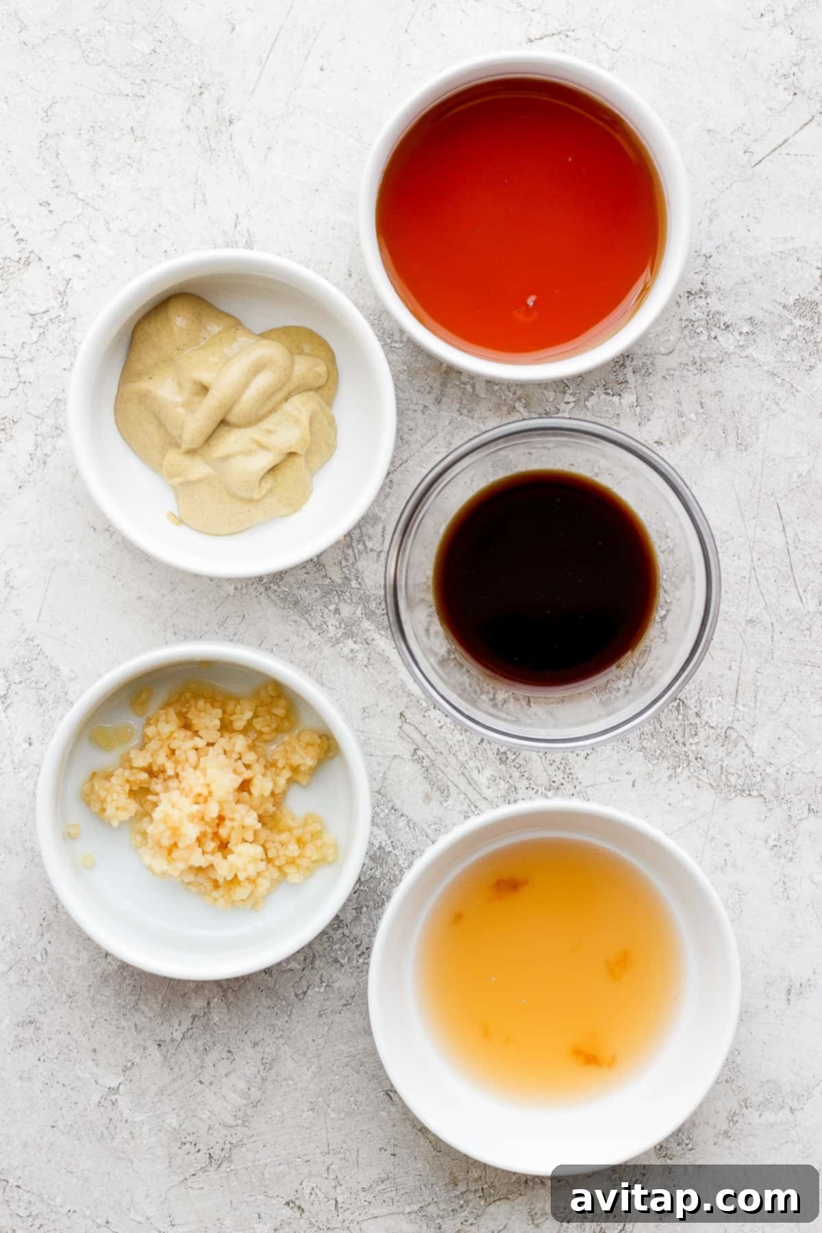 A vibrant display of the individual components of the maple dijon rib marinade in small bowls.