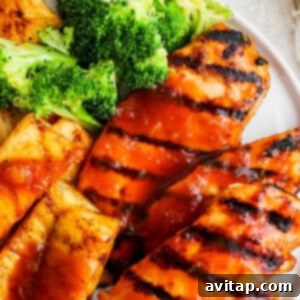 A white plate topped with chicken and broccoli.