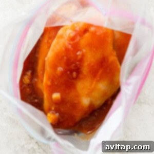 A close-up of chicken marinating in a plastic bag.