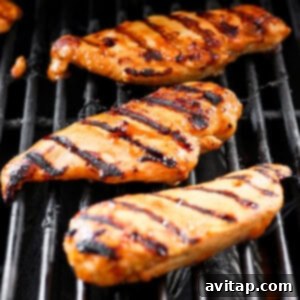 A close-up of a grill with chicken on it.