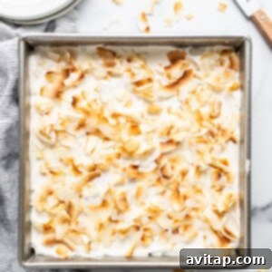A pan filled with a dessert covered in coconut flakes.