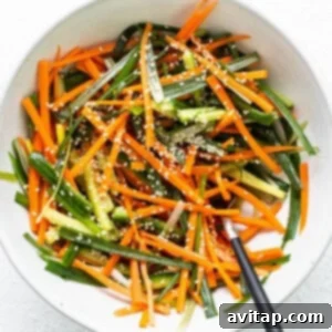 A white bowl filled with carrots and green beans, showcasing fresh, colorful ingredients.