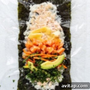 A sushi platter with salmon, avocado, carrots, and other fresh ingredients arranged for assembly.