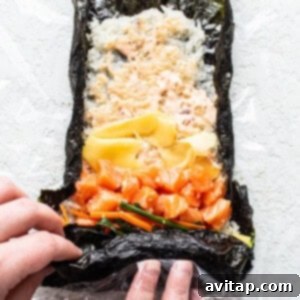 A person expertly holding a freshly rolled sushi burrito, demonstrating its perfect size and convenience.