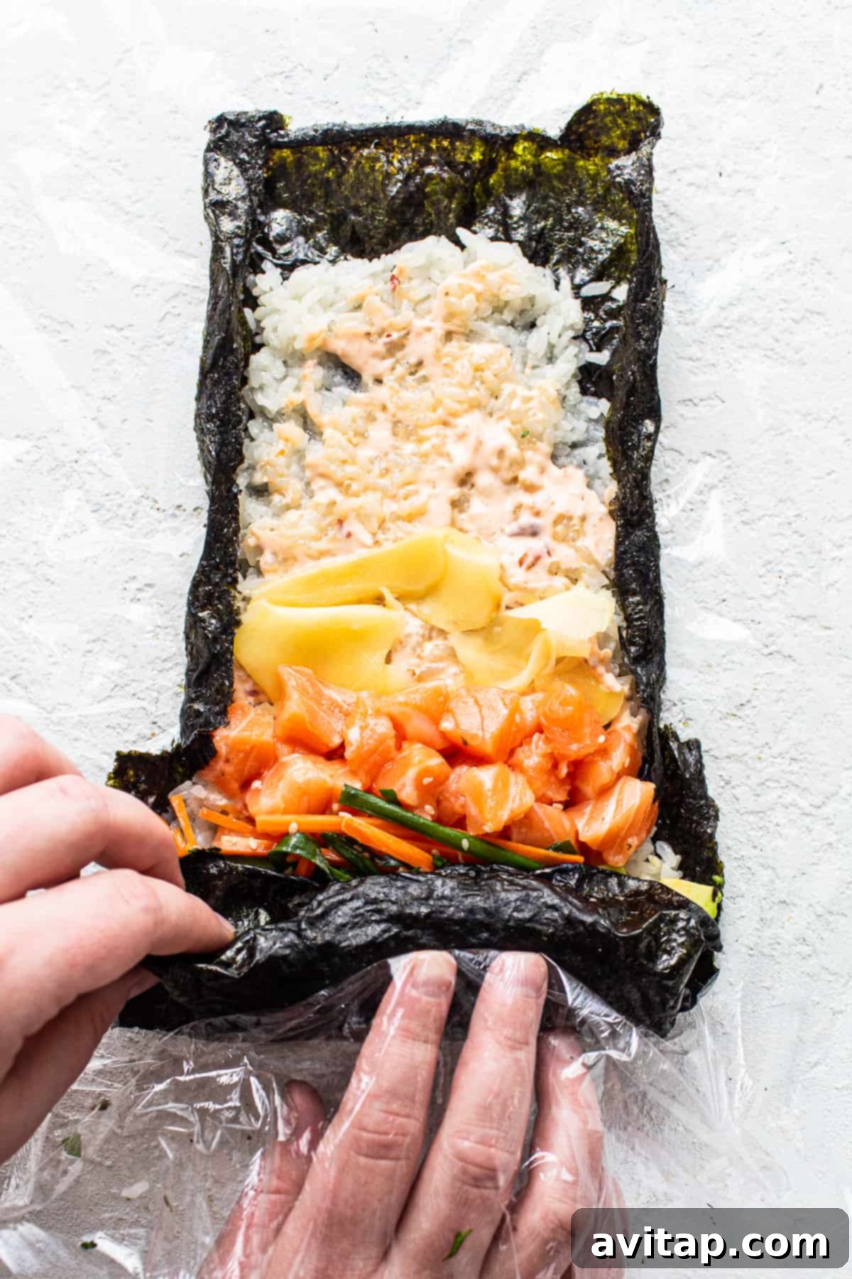 A hand gently holding a freshly rolled sushi burrito, demonstrating the perfect size and delicious potential of this handheld meal.