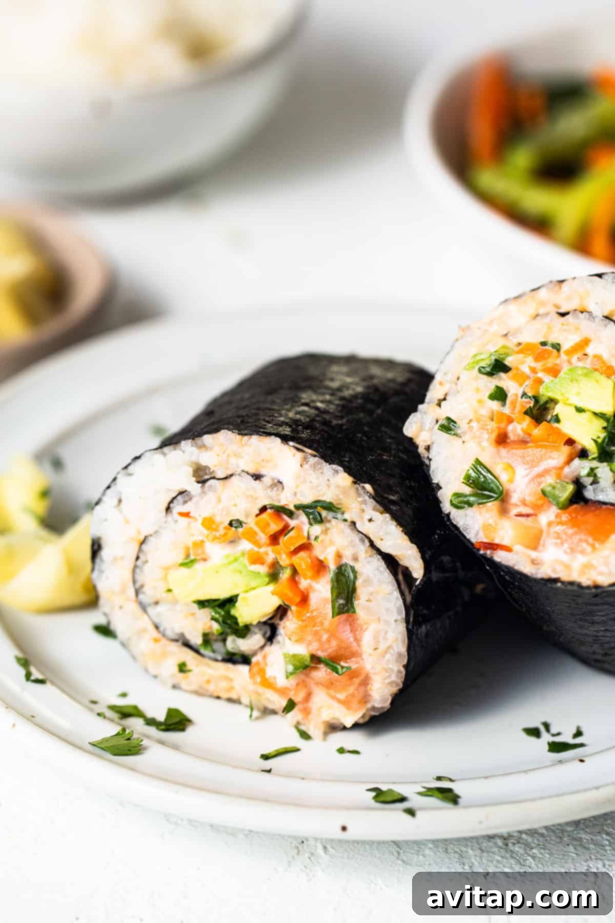 A elegantly plated salmon sushi burrito alongside a delicate bowl of fresh vegetables, emphasizing the balanced components of the dish.