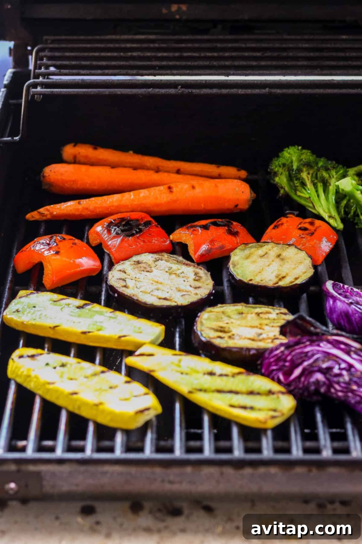 Carrots, broccoli, and other colorful vegetables sizzling on a hot BBQ grill, creating delicious char marks.