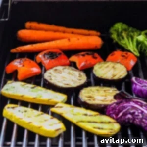 Carrots, broccoli, and other colorful vegetables cooking on a BBQ grill, showing the grilling process.
