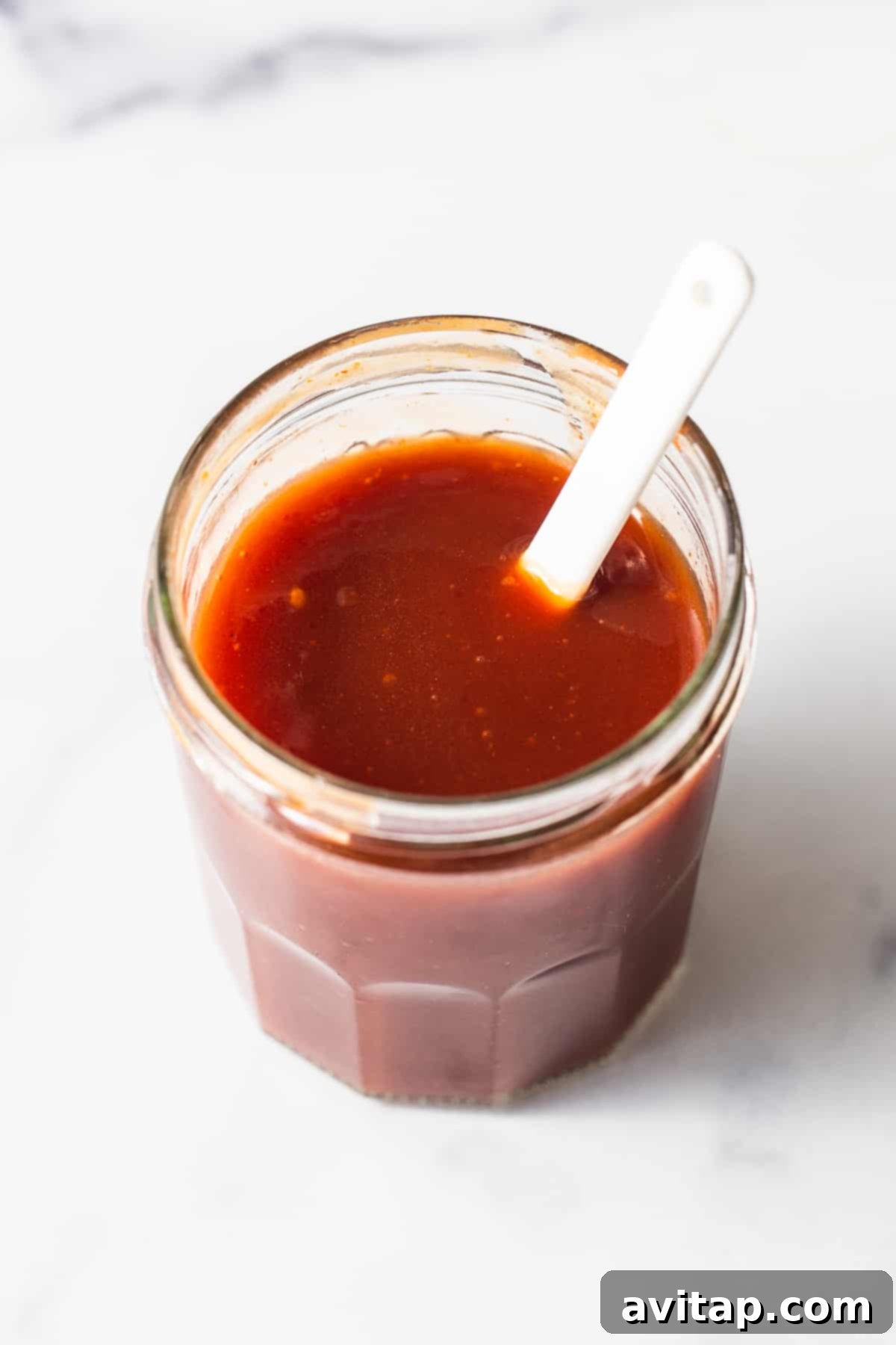 firecracker sauce in a jar with a spoon, ready to be served or stored.