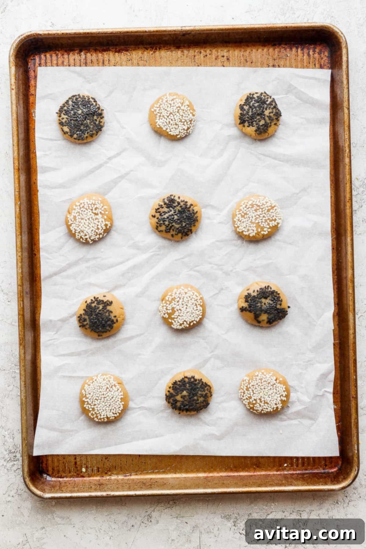 Freshly baked sesame tahini cookies cooling on a wire rack, showcasing their even golden-brown finish.