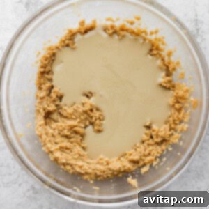 A glass bowl of creamy tahini, ready to be incorporated into the cookie dough.