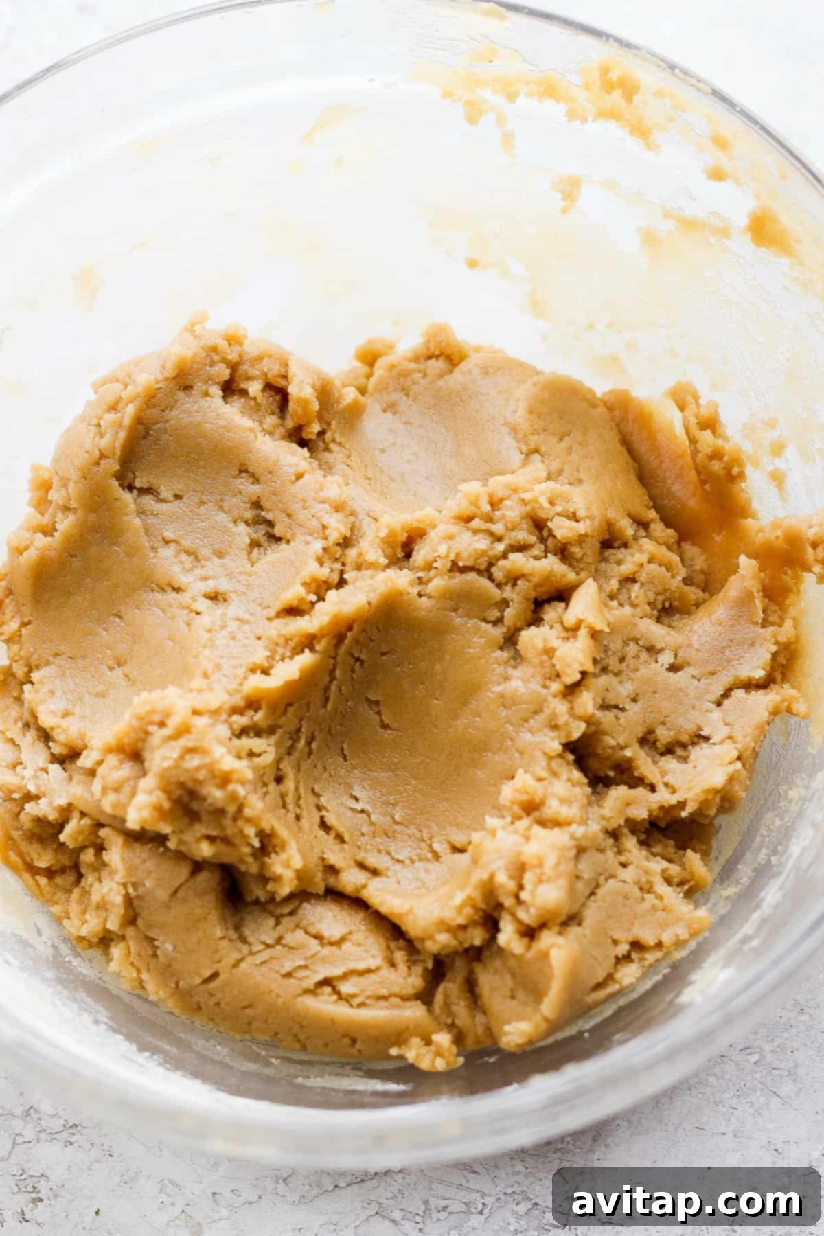 Smooth, creamy tahini resting in a clear glass bowl, showcasing its readiness for baking.