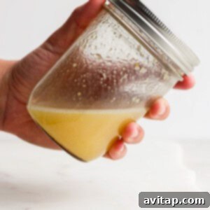 A person holding a jar of lemon juice.