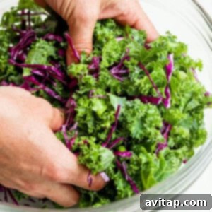 A person putting kale into a bowl.