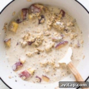 Dreamy Peach Overnight Oats 9 A bowl of oatmeal with apples and oats, covered for chilling.