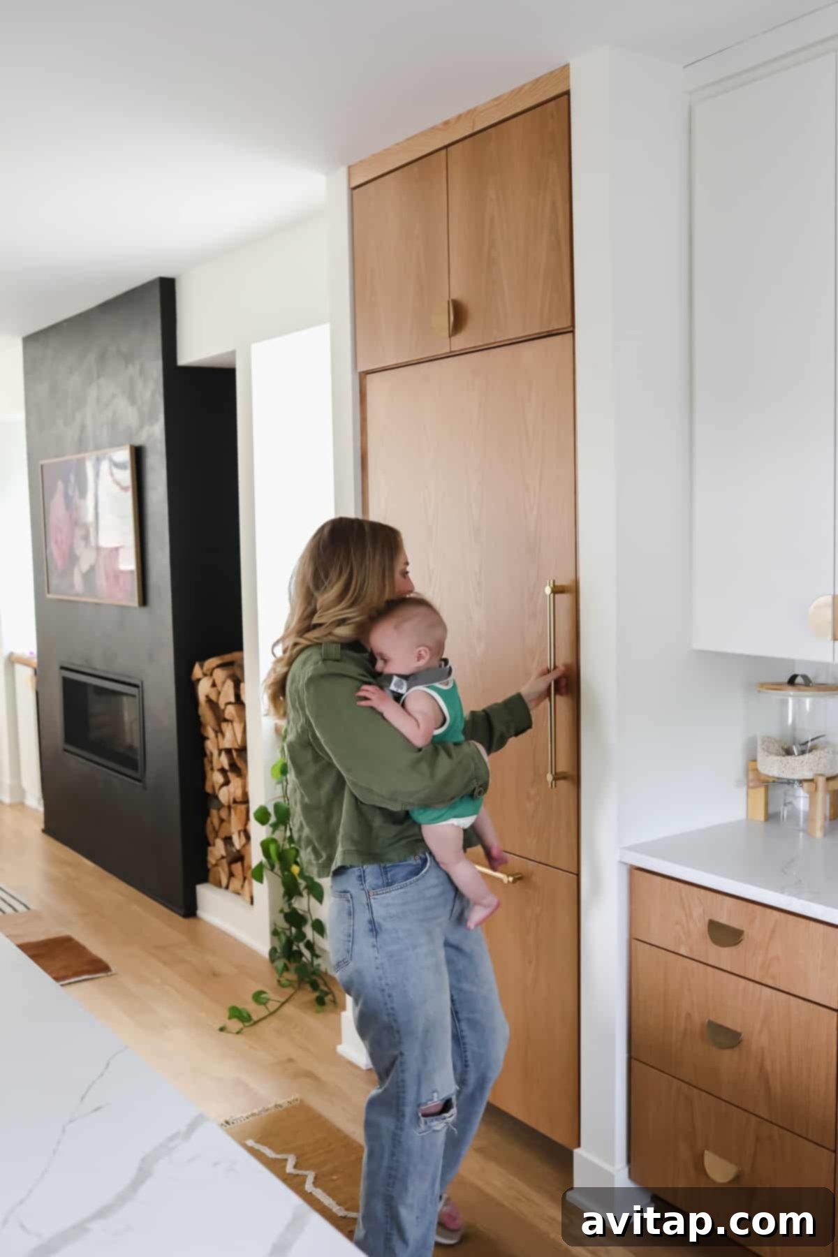 Lee happily opening her new panel-ready refrigerator, showcasing the seamless integration of Thermador appliances in her dream kitchen.