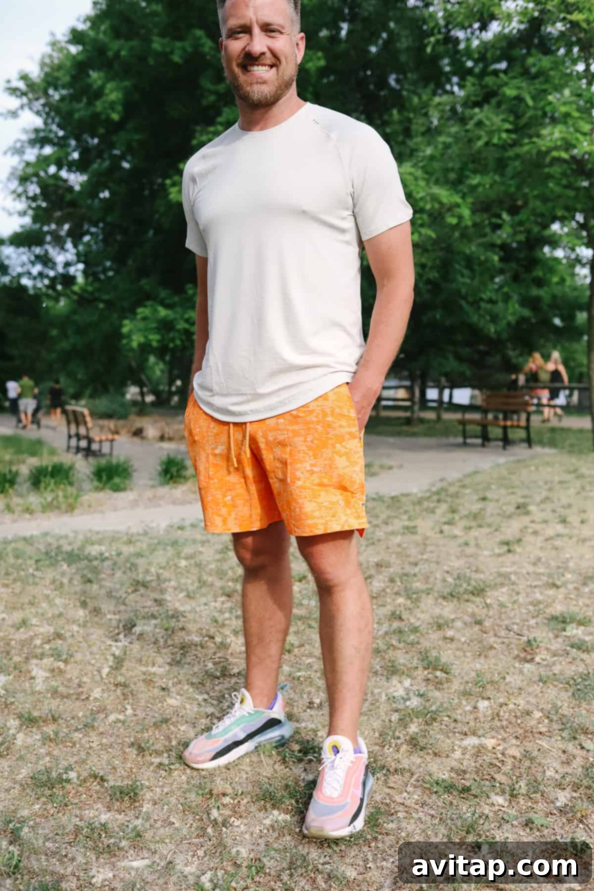 A man in License to Train shorts standing confidently in a field, hands in pockets, embodying active lifestyle.