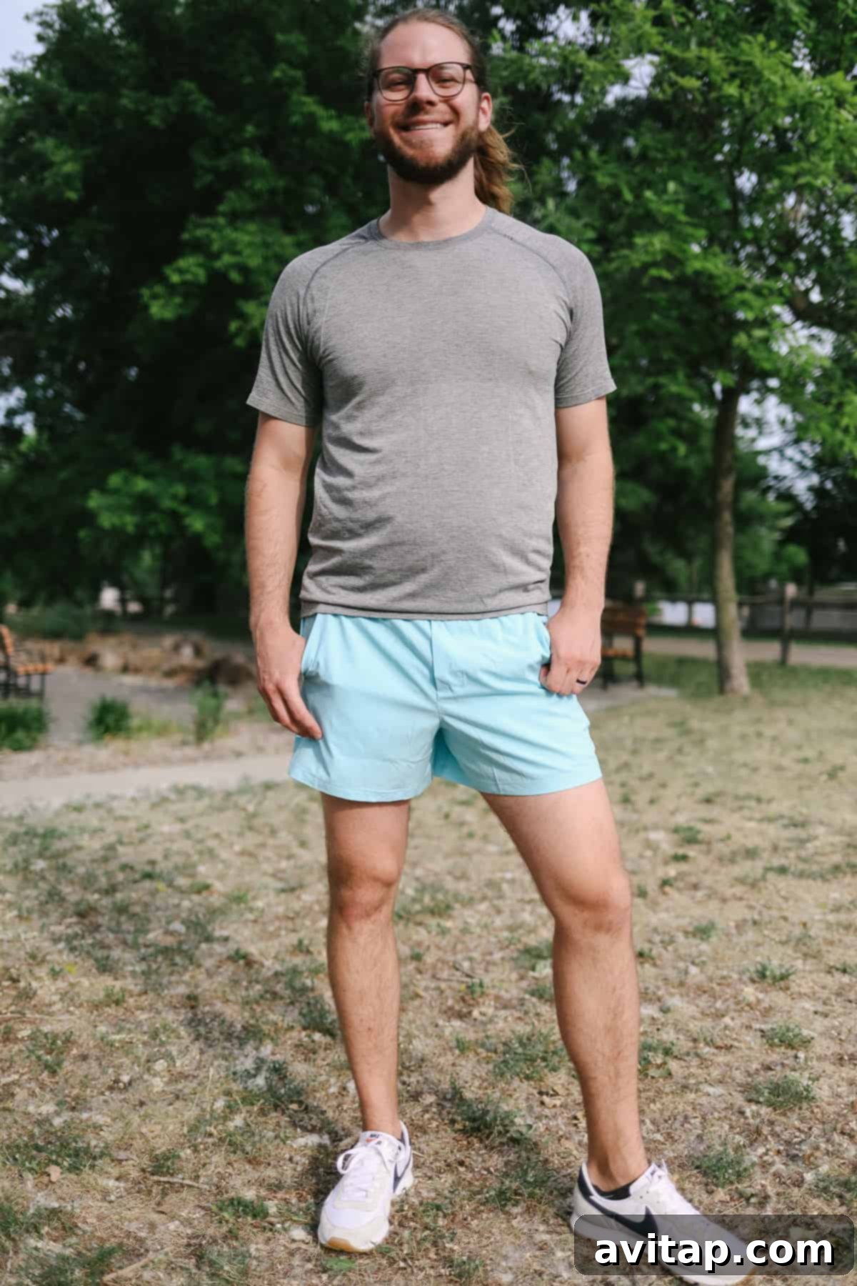 A man in Lululemon Pace Breaker shorts poses in a field, showcasing the short's athletic design.