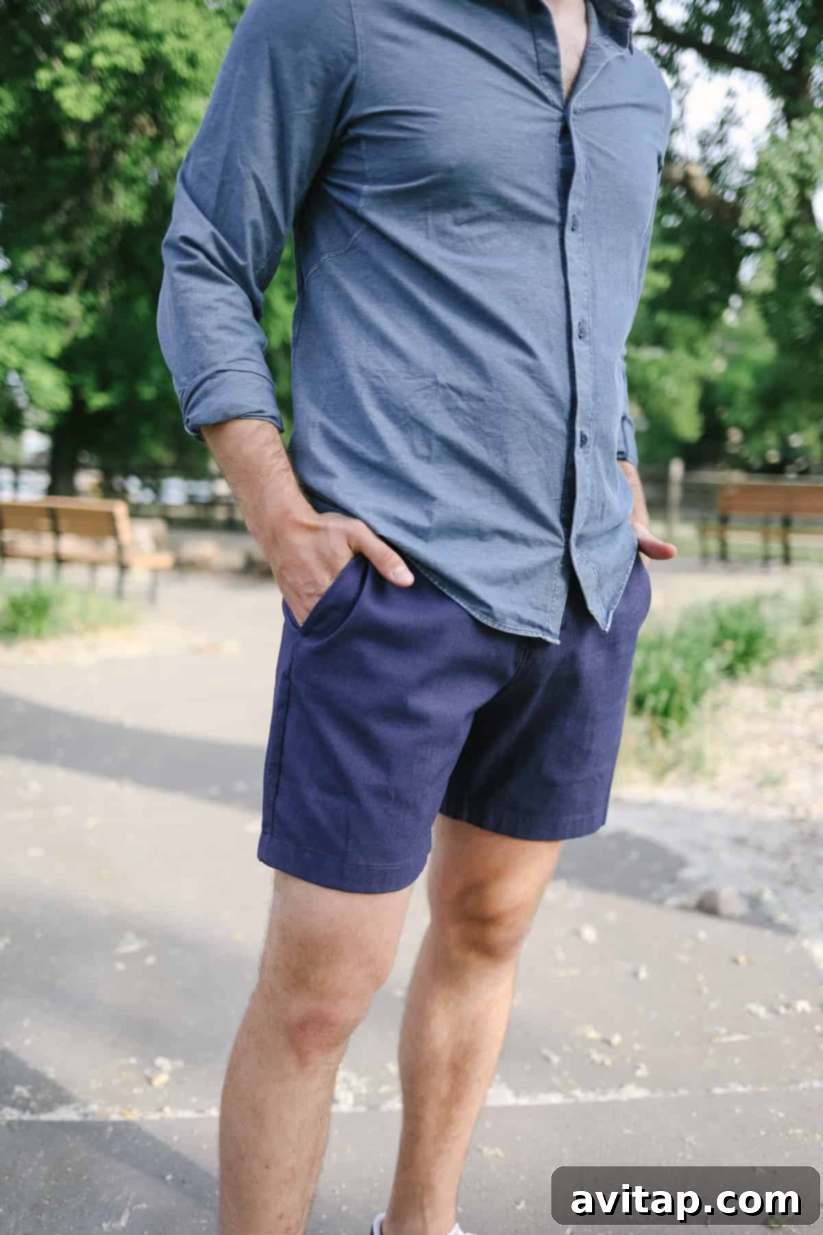 A man in a blue shirt and Lululemon Commission shorts posing confidently, showcasing their refined fit.