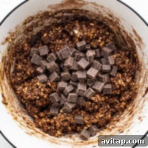 Chocolate granola in a bowl with chocolate chips, showing the rich, mixed cookie dough before chilling.