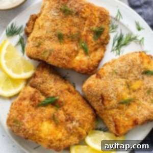 Crispy air fryer fish fillets resting on a white plate, ready to be served or added to tacos.