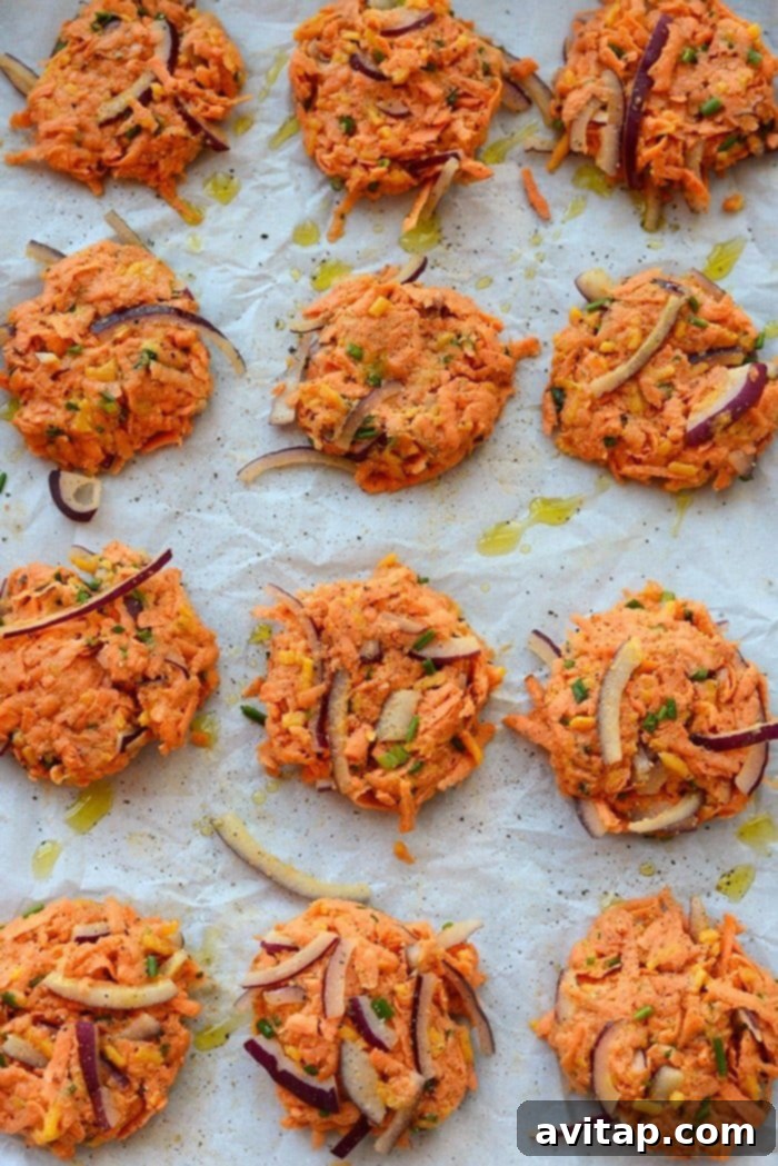 Pre-baked Sweet Potato Fritters Awaiting Golden Perfection Sweet potato hash brown fritters perfectly formed and ready to be baked on a parchment-lined sheet.