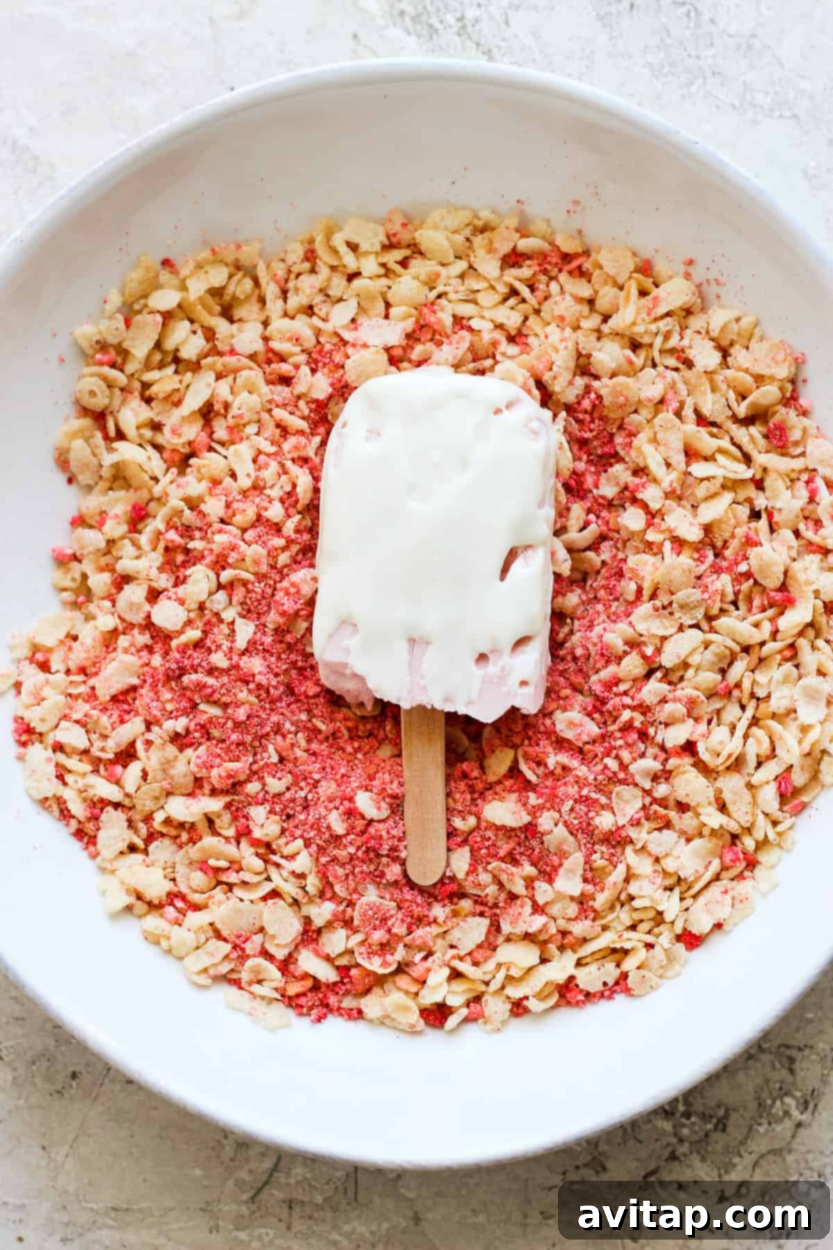 A high-protein strawberry shortcake bar garnished with granola in a white bowl.