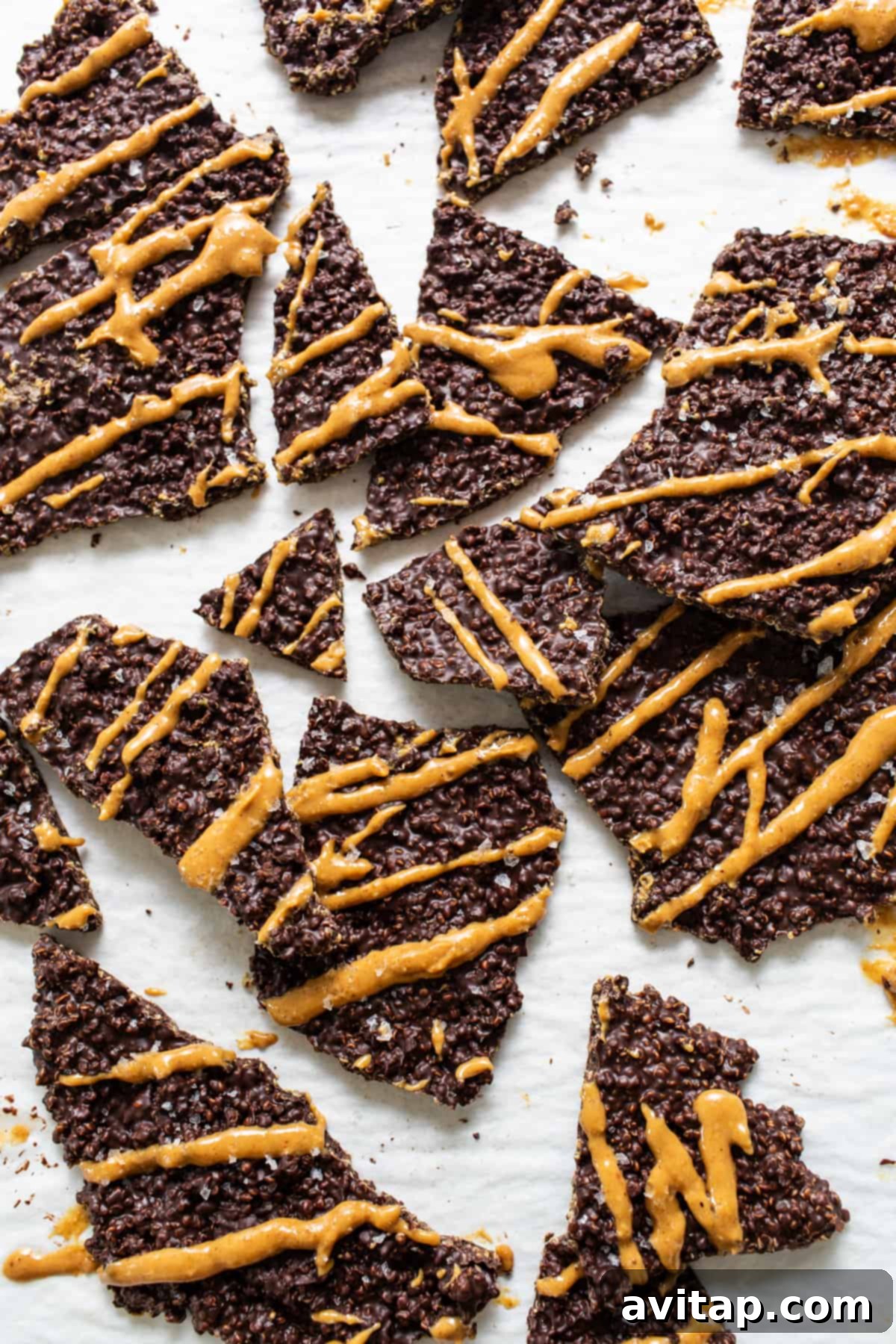 Chocolate Quinoa Crunch 2 A vibrant pile of chocolate quinoa crisps, generously drizzled with golden peanut butter and a sprinkle of flaky sea salt, ready to be enjoyed as a wholesome dessert.