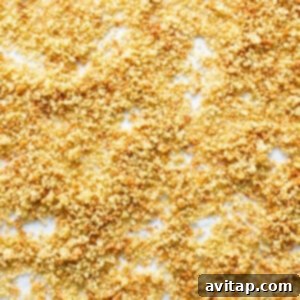A baking sheet filled with quinoa toasting in the oven, emphasizing the preparation step.