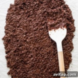 Chocolate quinoa mixture spread on a tray with peanut butter drizzle and sea salt.