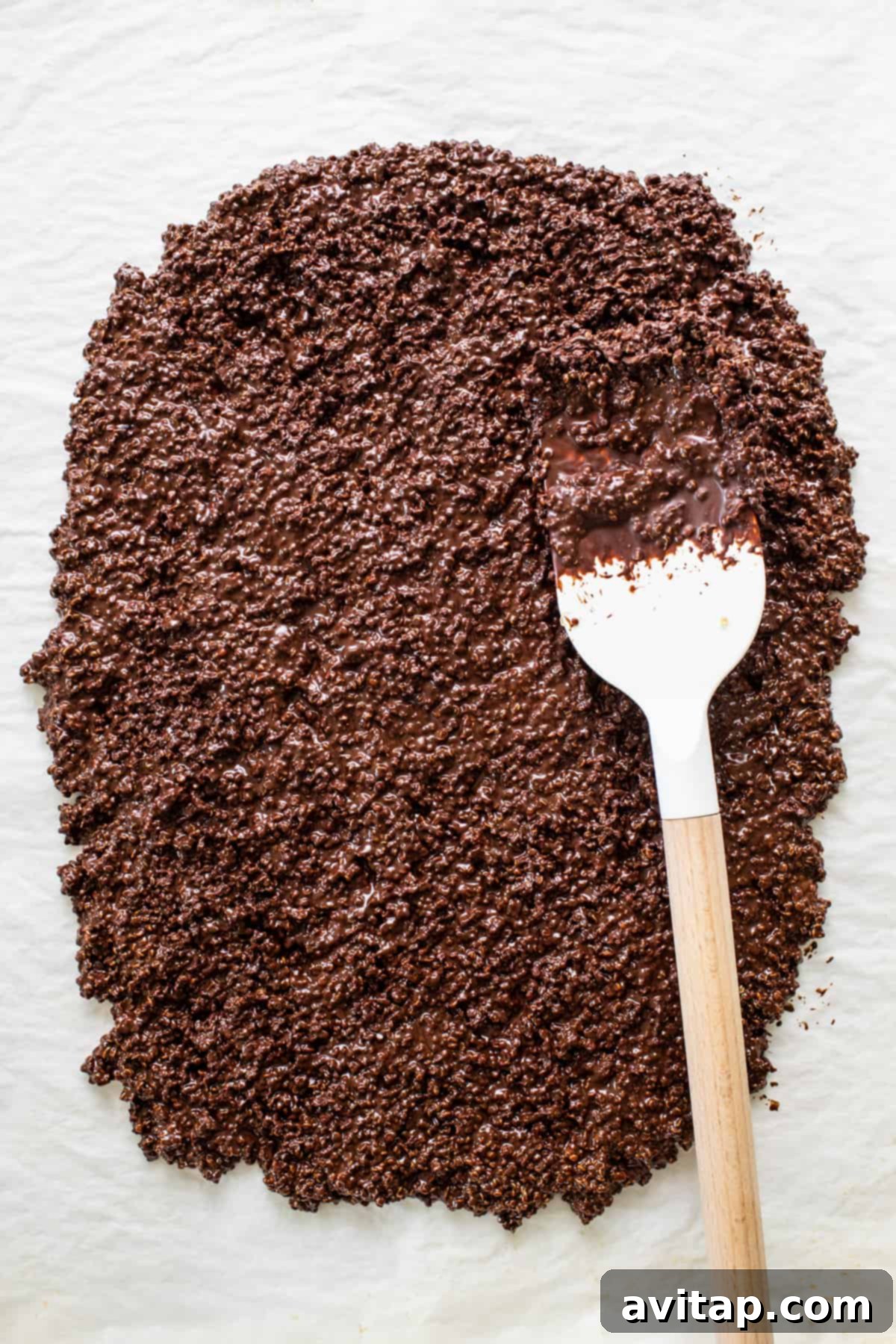 Chocolate Quinoa Crunch 4 A close-up shot of a spoon filled with dark chocolate shavings and cocoa powder, symbolizing the rich ingredients of the crisps.