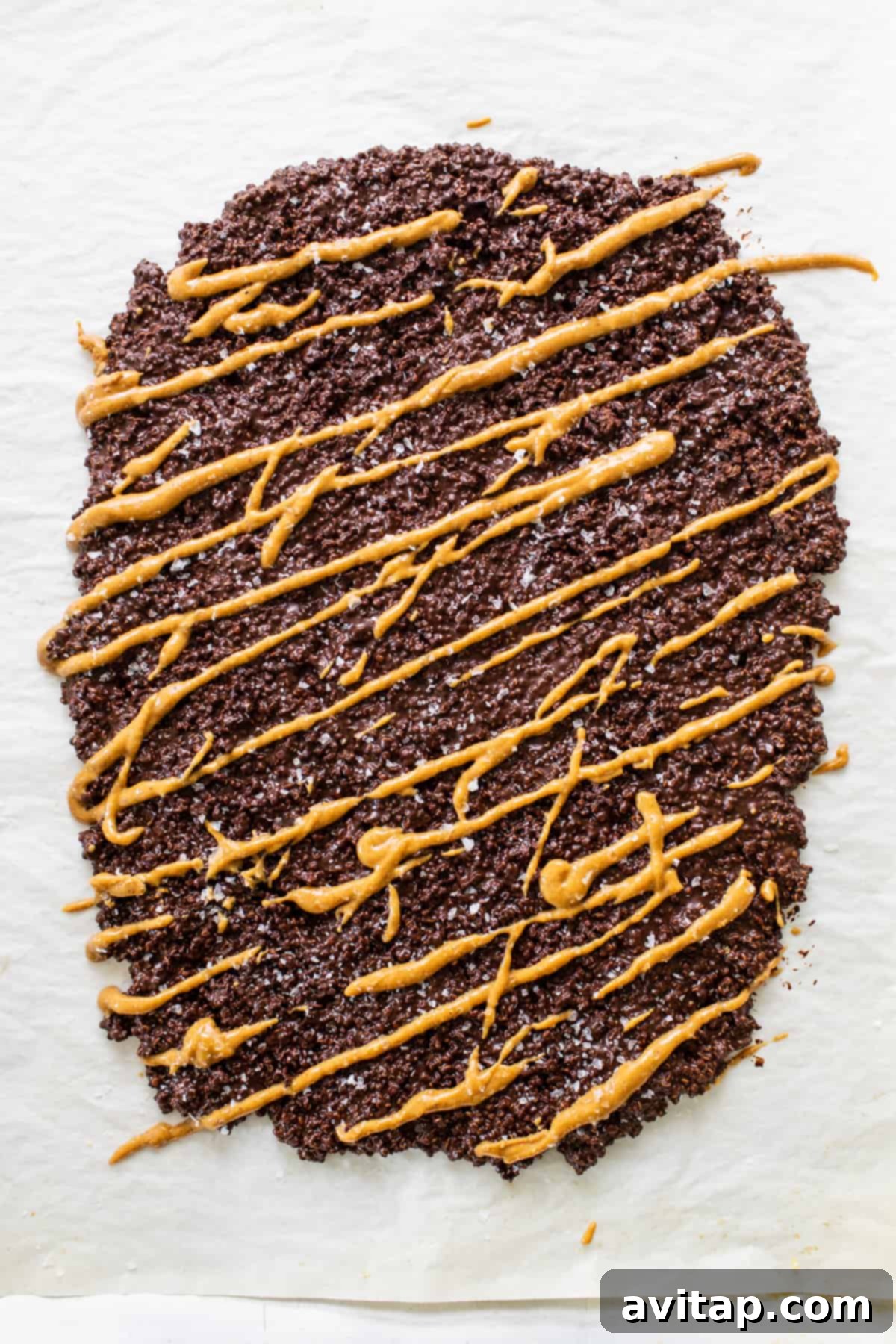 Chocolate Quinoa Crunch 5 A tantalizing piece of chocolate quinoa crisp, showcasing its crunchy texture and the delicious caramel-like drizzle on top.