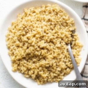 Cook quinoa in the microwave using a white bowl and spoon.