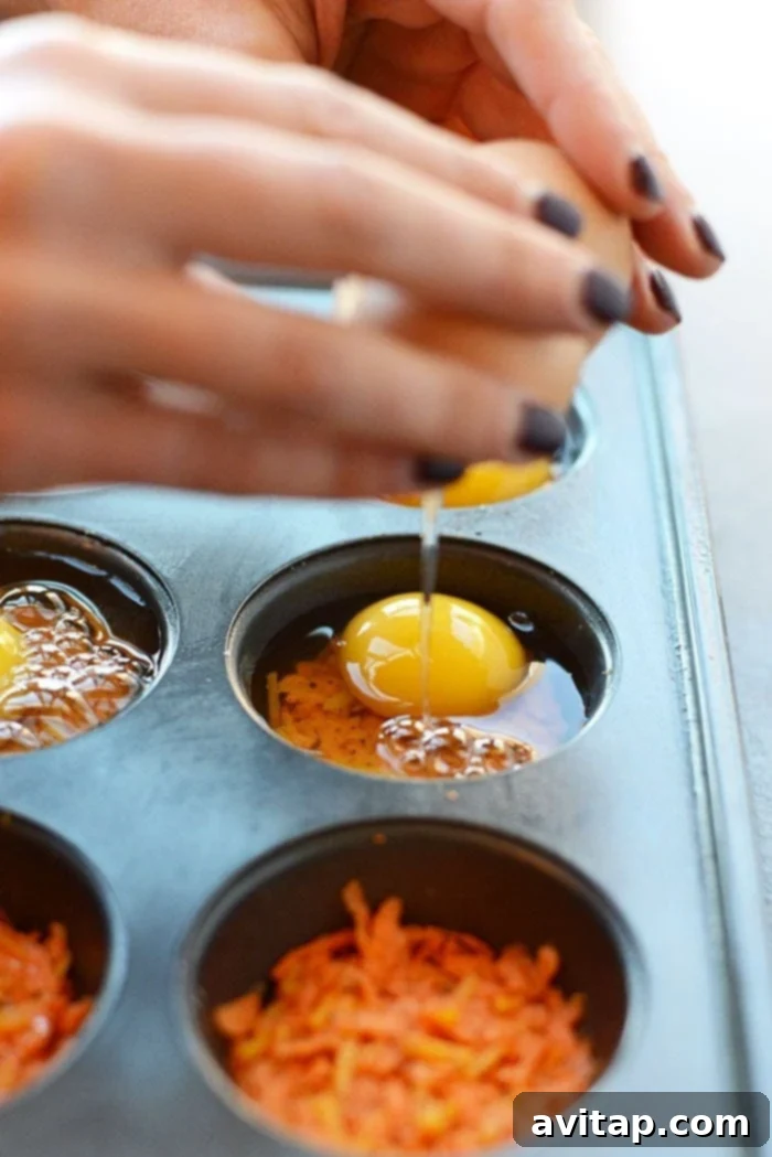 Sweet Potato Hash Egg Bites 3 Cracking an egg directly over the sweet potato hash in a muffin tin cup.