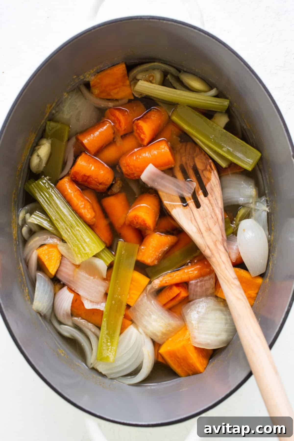 One-Pot Hidden Veggie O's 3 A large cooking pot filled with coarsely chopped carrots, celery, and onions, patiently simmering on a stovetop, highlighting the fresh, wholesome ingredients that form the broth.